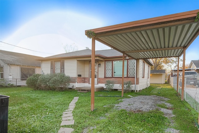 rear view of property with a lawn and a carport