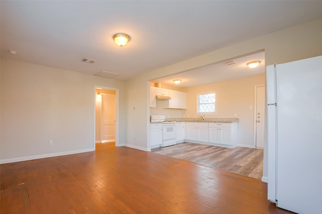 kitchen featuring white cabinets, wood-type flooring, and white appliances