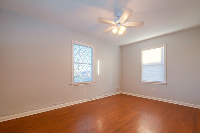 spare room featuring ceiling fan, a healthy amount of sunlight, and wood-type flooring