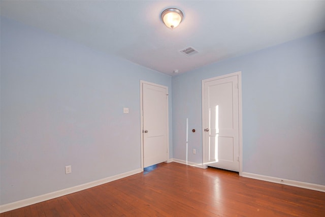 unfurnished room featuring dark wood-type flooring