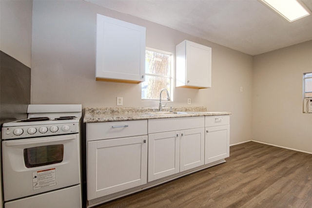 kitchen with light stone counters, white range oven, sink, white cabinets, and hardwood / wood-style floors