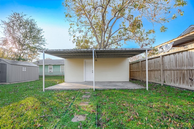 rear view of house with a shed, a carport, and a lawn