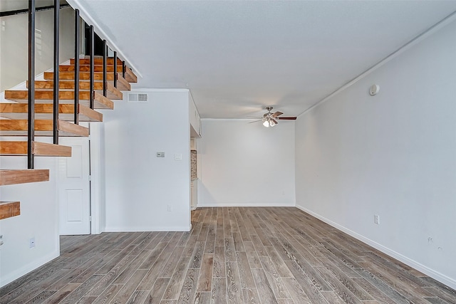 unfurnished living room with hardwood / wood-style floors, ceiling fan, and crown molding