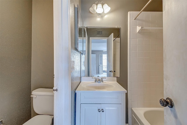 full bathroom with vanity, tiled shower / bath combo, and toilet