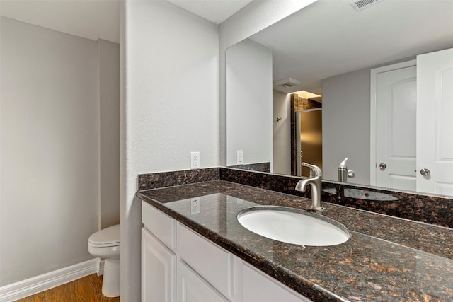 bathroom with vanity, toilet, and wood-type flooring