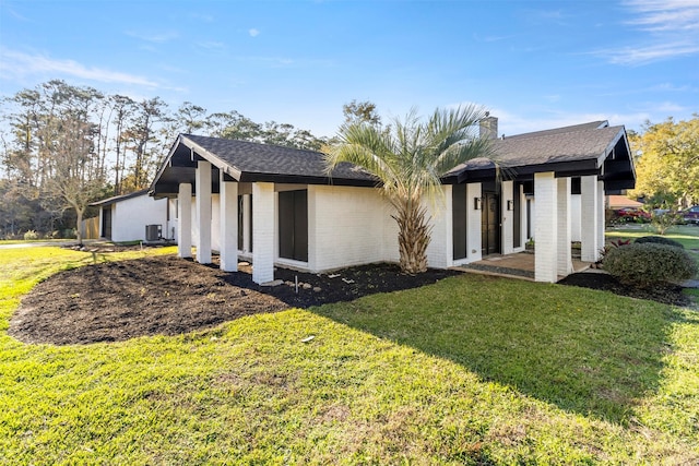 exterior space with a front yard and central air condition unit