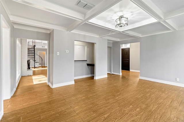 unfurnished living room featuring beamed ceiling, light hardwood / wood-style flooring, and coffered ceiling