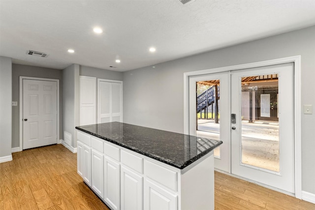 kitchen featuring white cabinetry, french doors, a center island, and light hardwood / wood-style floors