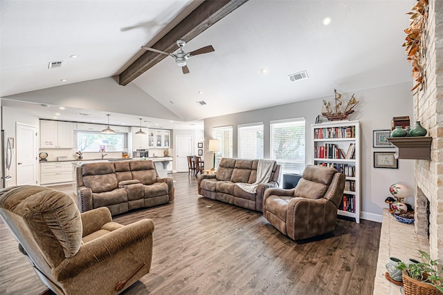 living room featuring hardwood / wood-style floors, high vaulted ceiling, a brick fireplace, ceiling fan, and beamed ceiling