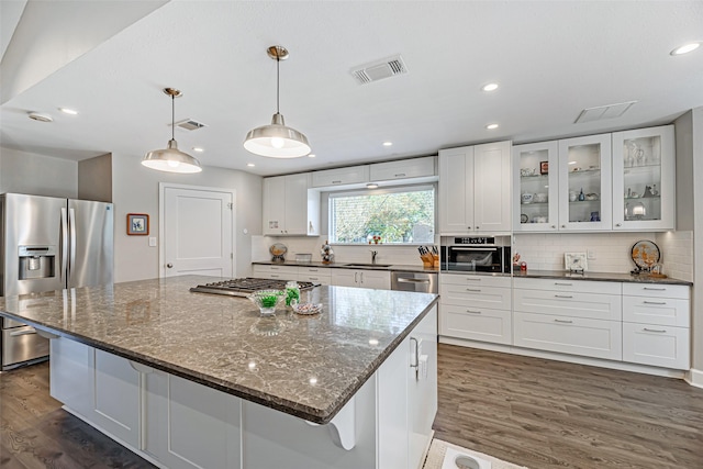 kitchen featuring pendant lighting, a center island, white cabinets, and stainless steel appliances