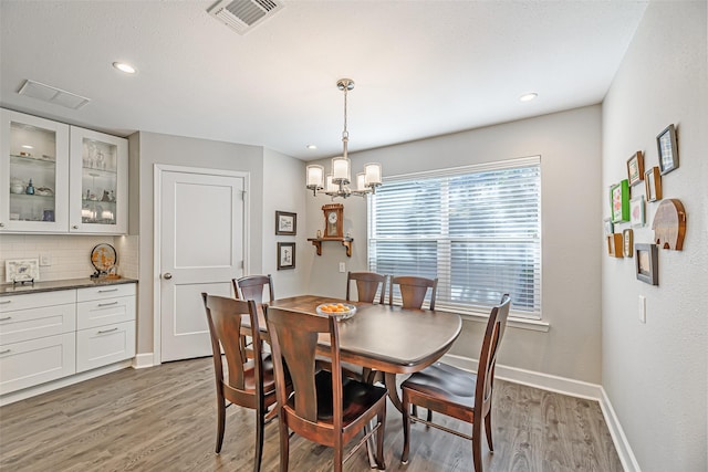 dining space featuring dark hardwood / wood-style flooring and an inviting chandelier