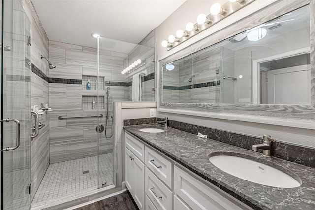 bathroom featuring hardwood / wood-style flooring, vanity, and walk in shower