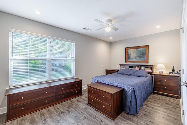 bedroom with multiple windows, ceiling fan, and light hardwood / wood-style flooring