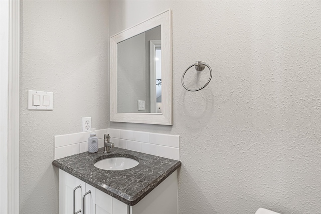 bathroom featuring vanity and backsplash