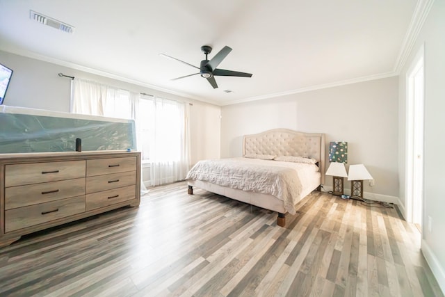 bedroom featuring hardwood / wood-style flooring, ceiling fan, and crown molding