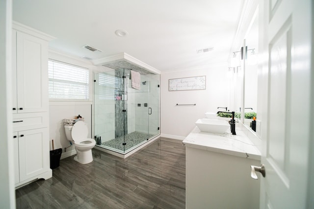 bathroom featuring hardwood / wood-style floors, toilet, a shower with door, vanity, and ornamental molding