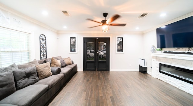 living room featuring a fireplace, ceiling fan, ornamental molding, and dark wood-type flooring