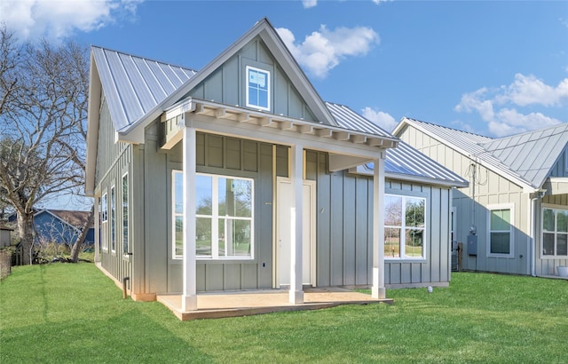 rear view of property featuring a lawn