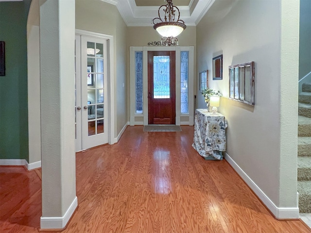 entrance foyer with a tray ceiling, light hardwood / wood-style flooring, and crown molding