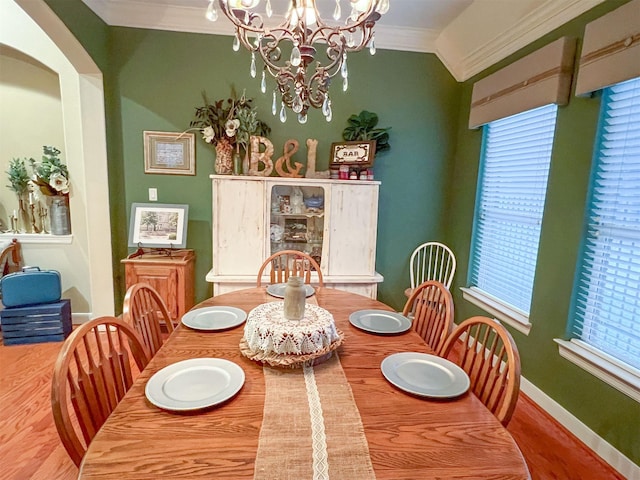 dining space featuring lofted ceiling, crown molding, and a chandelier