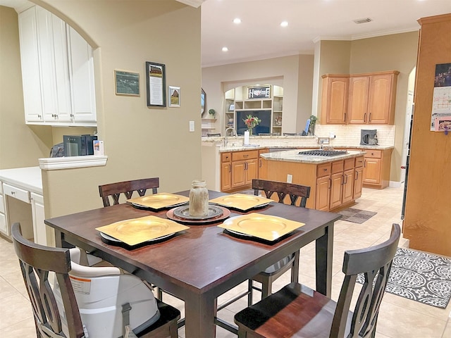 tiled dining space with sink and ornamental molding