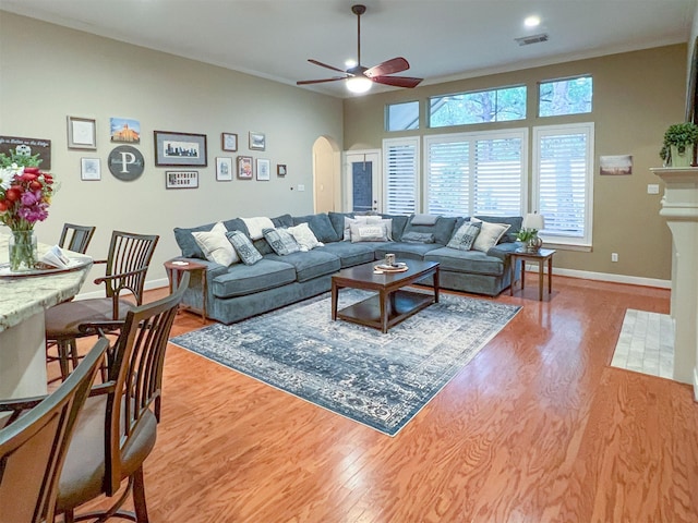 living room featuring ceiling fan, hardwood / wood-style flooring, and crown molding