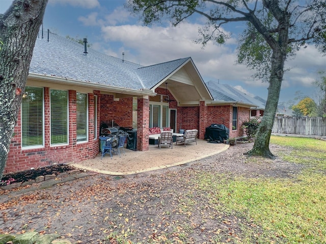 back of property featuring a patio area and an outdoor hangout area