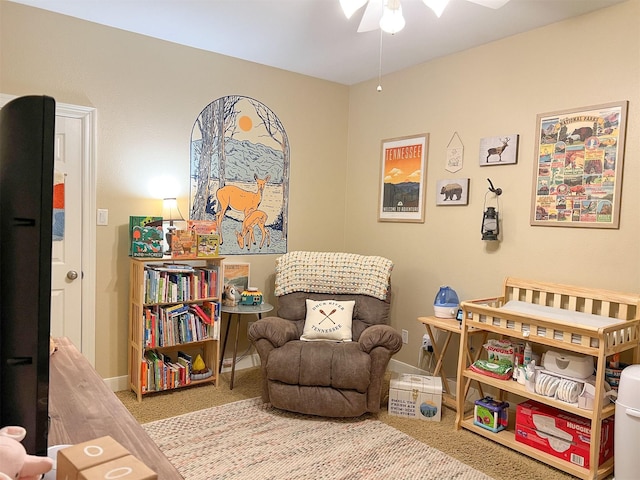 sitting room with ceiling fan and carpet flooring