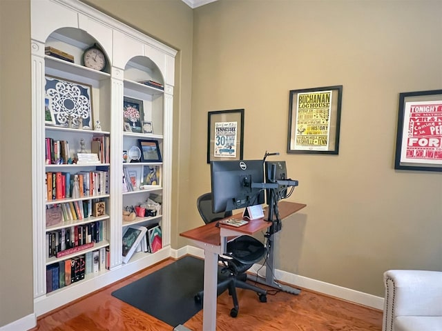 office space with built in shelves and wood-type flooring