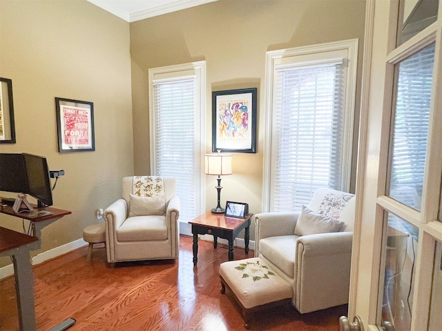 sitting room with wood-type flooring and crown molding