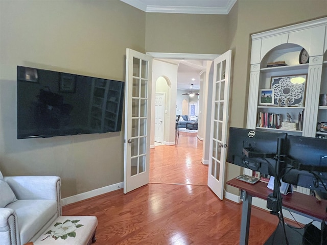 living area featuring wood-type flooring, ornamental molding, and french doors