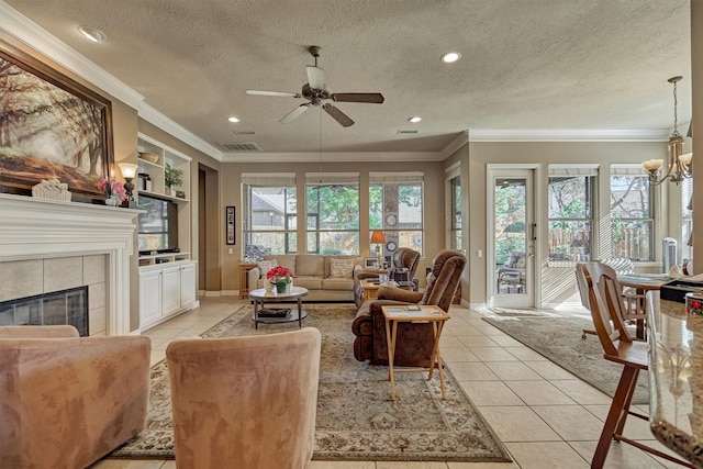 living room with built in shelves, a tile fireplace, a textured ceiling, light tile patterned floors, and ceiling fan with notable chandelier