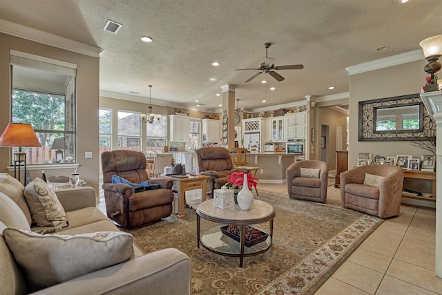 living room featuring ceiling fan with notable chandelier, light tile patterned flooring, crown molding, and a textured ceiling