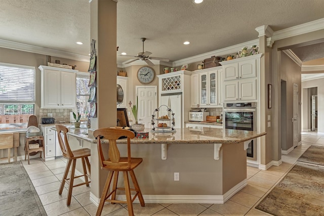 kitchen with white cabinetry, light tile patterned floors, and a textured ceiling