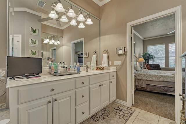 bathroom featuring tile patterned floors, vanity, crown molding, and a textured ceiling