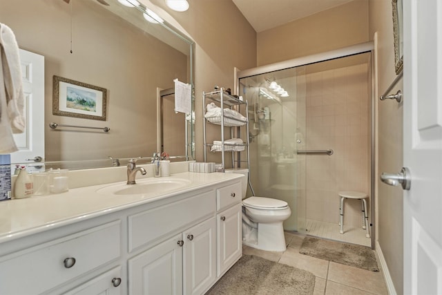 bathroom featuring tile patterned flooring, vanity, toilet, and an enclosed shower