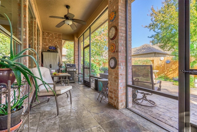 unfurnished sunroom with ceiling fan