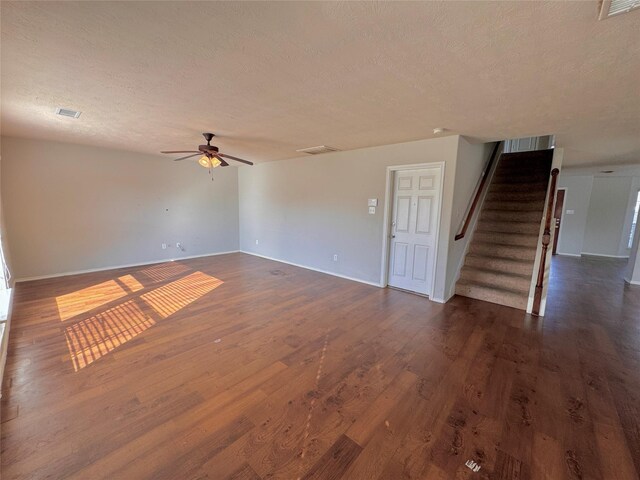 unfurnished living room with ceiling fan, dark hardwood / wood-style flooring, and a textured ceiling