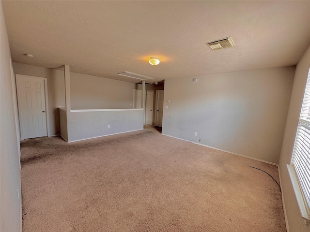 carpeted empty room featuring a textured ceiling