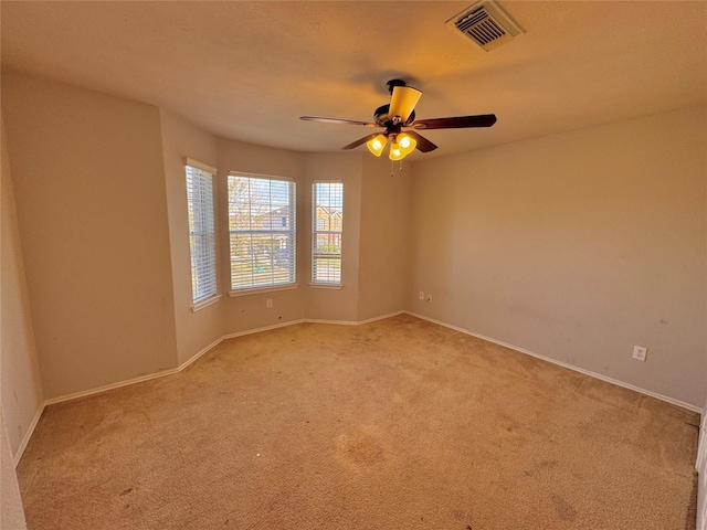 carpeted spare room with ceiling fan