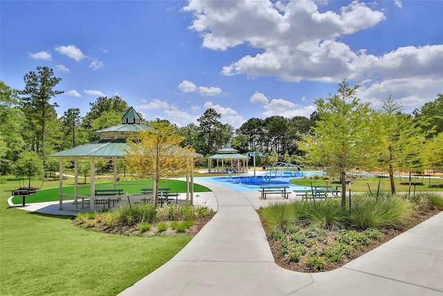 view of community with a gazebo, a pool, and a lawn