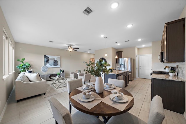 tiled dining room with sink and ceiling fan