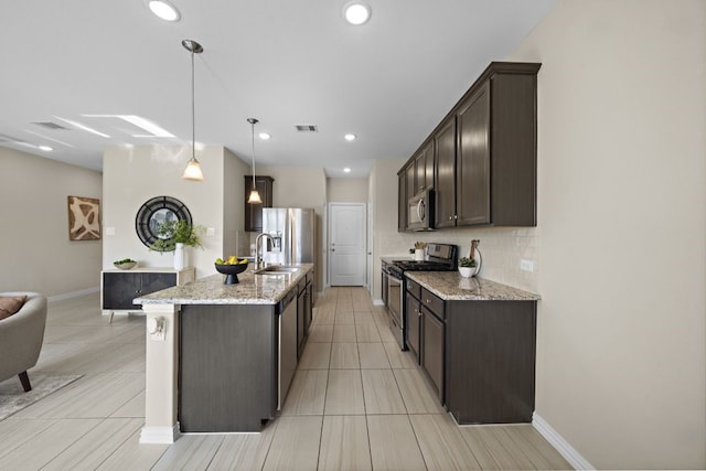 kitchen featuring sink, dark brown cabinets, pendant lighting, stainless steel appliances, and light stone countertops