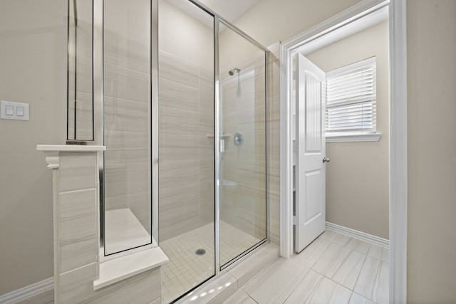 bathroom featuring a shower with door