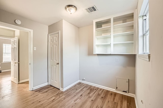 laundry area with light hardwood / wood-style floors