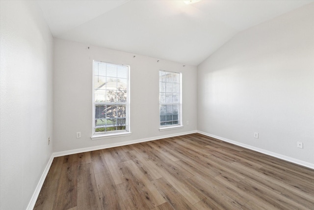 unfurnished room with hardwood / wood-style flooring and vaulted ceiling