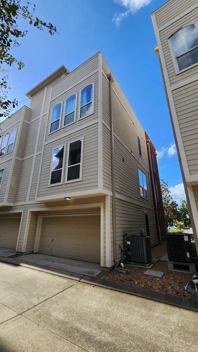 view of side of home featuring a garage and central AC unit