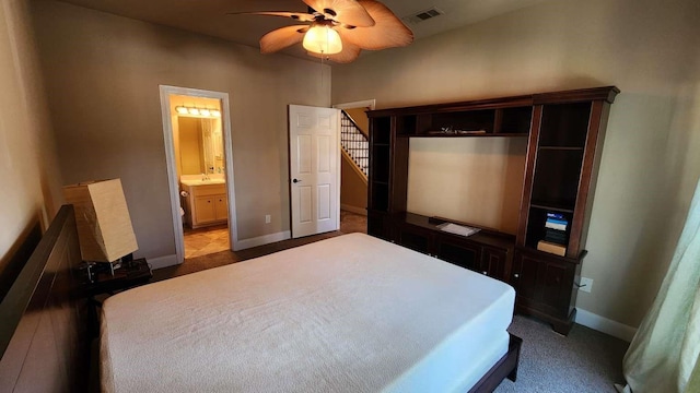 carpeted bedroom with ensuite bath and ceiling fan