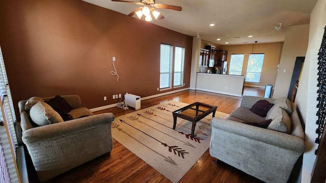 living room with ceiling fan and dark wood-type flooring