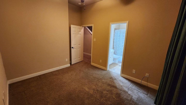 unfurnished room with carpet flooring and a towering ceiling